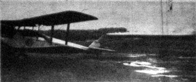 Luftvärnförbundets maskin Pilvetär på besök. Mot bakgrunden avtecknar sig den rökridå, som vägledde Södermanland vid landningen.