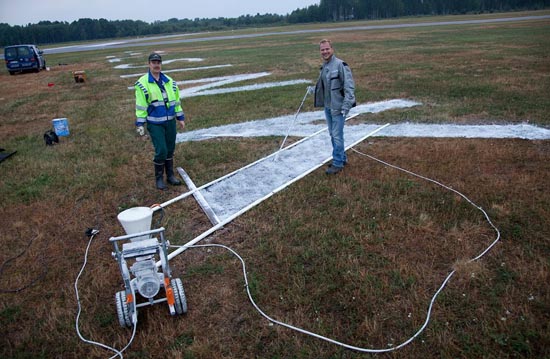 Klaus Wesa and Harri Kanto spraying temporary paint on the 6-meter-high letters. Photo: Finavia